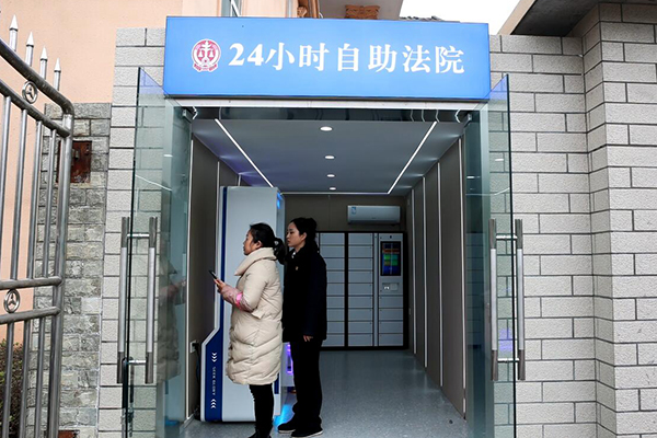 24小时自助法院 打通服务群众“最后一公里”_fororder_工作人员指引办事群众操作使用24小时自助法院