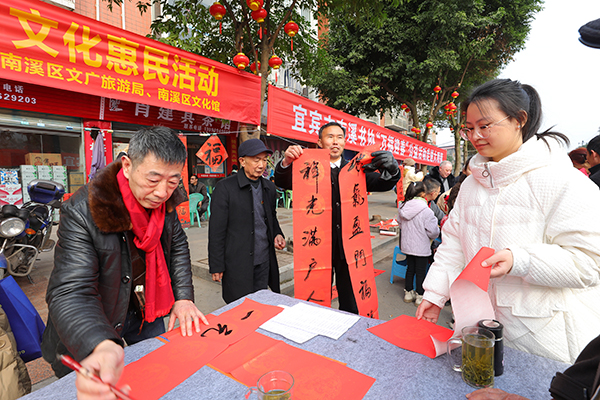 2024宜宾首届和美乡村文化节南溪区分会场活动启动_fororder_文化惠民送春联-供图-南溪区委宣传部