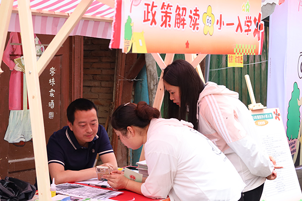 简阳：“文明风”碰撞“市井气” 古镇“文明集市”火热开启_fororder_简阳市教育局为市民解读入学政策（图---简阳市委宣传部）