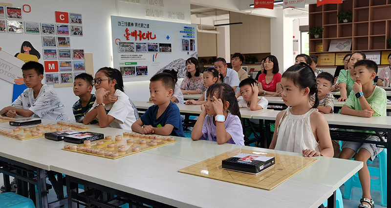 宜宾三江新区光明社区“奕趣之家”棋类培训班开班_fororder_小棋手们聚精会神听讲-摄影-高学兵
