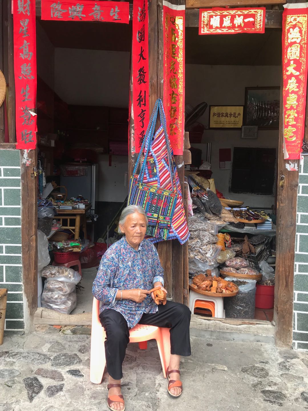 图片默认标题_fororder_老人们怡然自得在家里摆摊出售土楼特产。