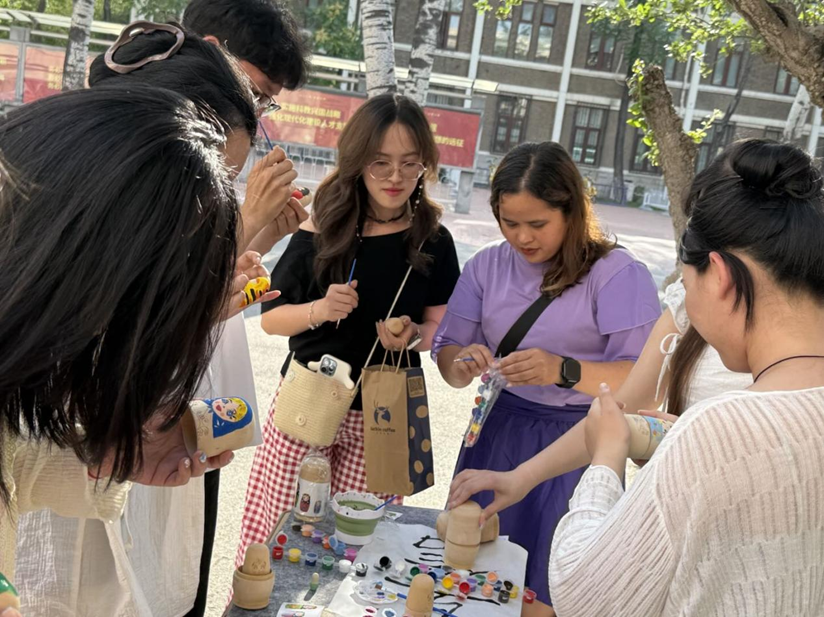 南开大学举办“语通上合 · 戏汇丝路”主题活动_fororder_柬埔寨留学生莲花与陈慧英参与体验俄罗斯套娃彩绘