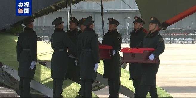 43名搬运烈士遗骸棺椁的礼兵正按序下机 对棺椁进行整理