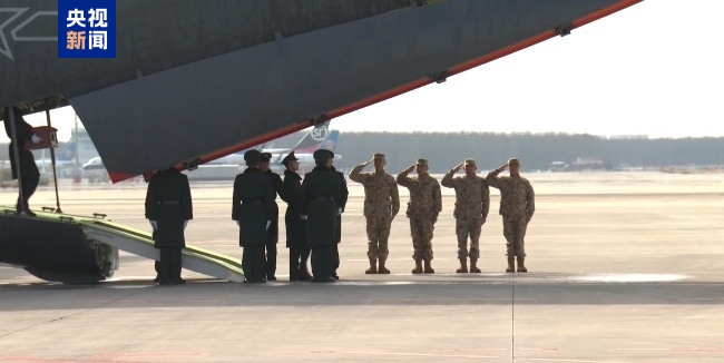 43名搬运烈士遗骸棺椁的礼兵正按序下机 对棺椁进行整理