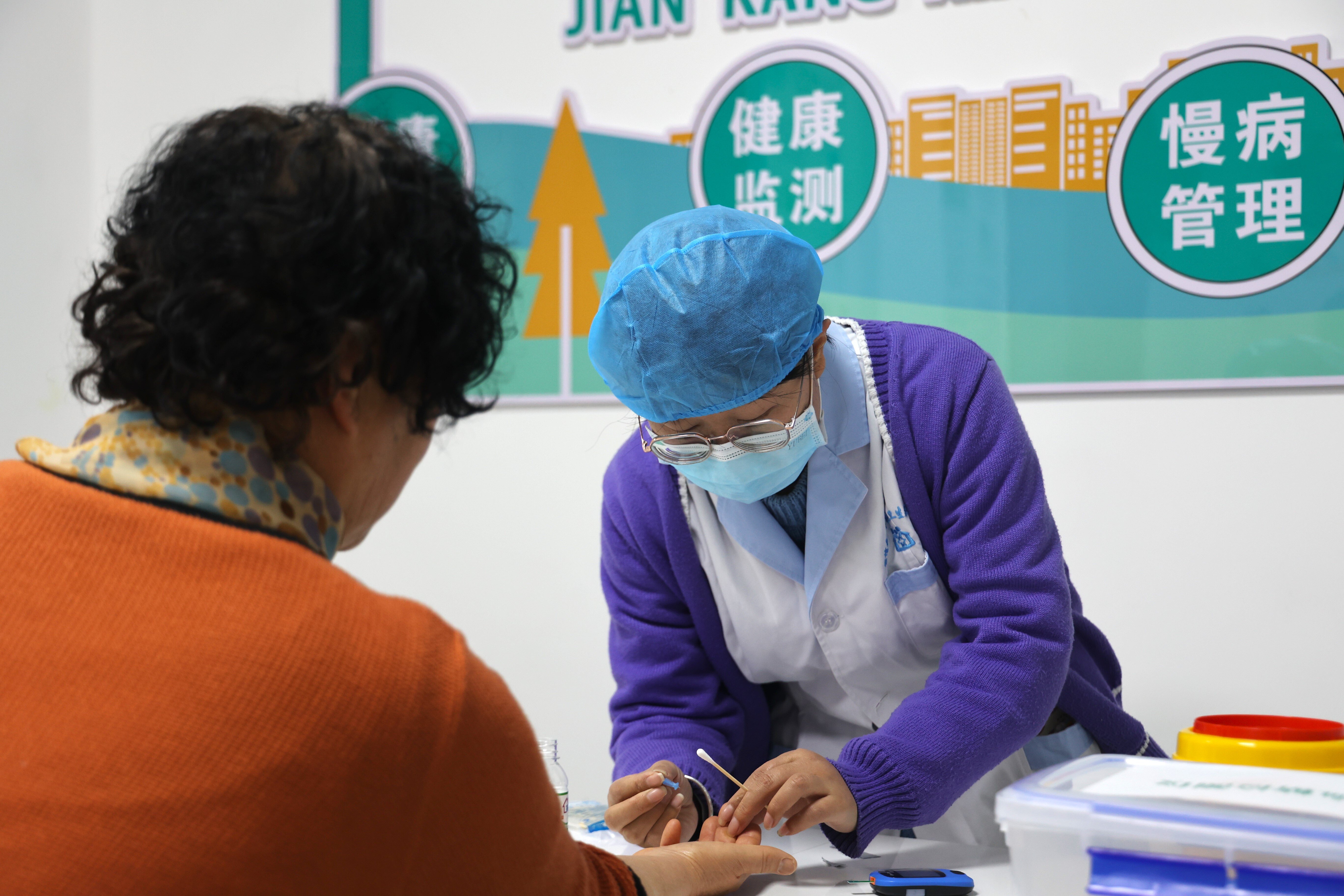 【原创】平凉崇信：开在家门口的“健康小屋”_fororder_图为崇信县“健康小屋”内工作人员正在为群众测量血糖_proc