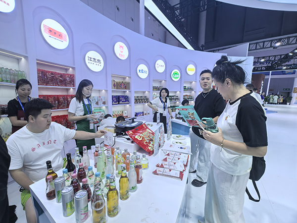 多点开花 眉山丹棱工业产品实力出圈_fororder_西博会上，威兰特食品展台前，观众驻足品尝