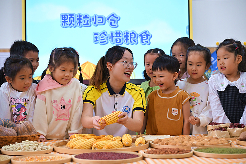 眉山仁寿：识五谷 惜粮食_fororder_2025年10月15日，四川省眉山市仁寿县城北幼儿园开展“珍惜粮食”主题教育活动，老师正在指导小朋友辨识五谷杂粮。01