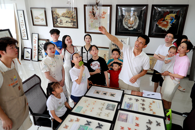 泸州纳溪：暑期实践共成长 非遗传承润童心_fororder_图为王世宏在为暑期社会实践的师生和孩子们讲解蝴蝶画。--廖胜春-摄-(1)