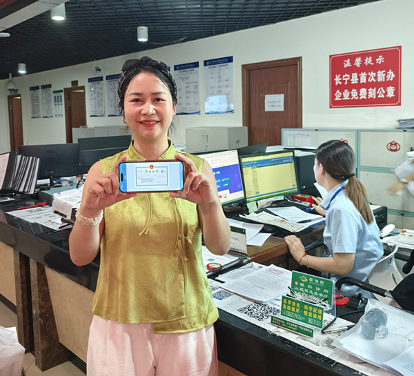 宜宾长宁：指尖一点就秒办 企业群众齐点赞_fororder_市民李女士申领“电子营业执照”现场-供图-长宁县融媒体中心