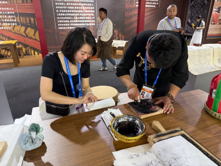 西博会启幕 甘孜文旅凭非遗与自驾路线实力“圈粉”_fororder_西博会非遗展示互动体验区正在体验的观众 供图 甘孜州委宣传部